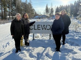 Ihmisiä tien vieressä clewor kyltin edessä