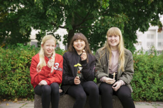 Kolme nuorta istuu puistossa