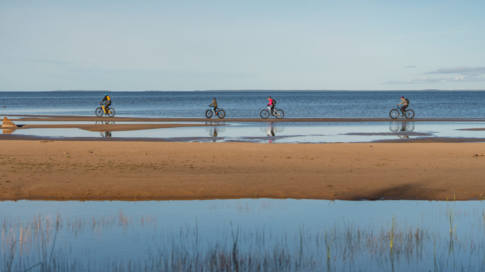 pyöräilijöitä meren rannassa